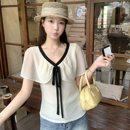 大きいサイズ レディースのアイボリー半袖ブラウス、黒配色Vネックとロングリボン、二の腕を包むシアーケープデザインの夏トップス着用イメージ